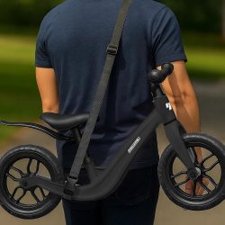 Črn otroški poganjalec z dvanajstpalčnimi kolesi na beli podlagi